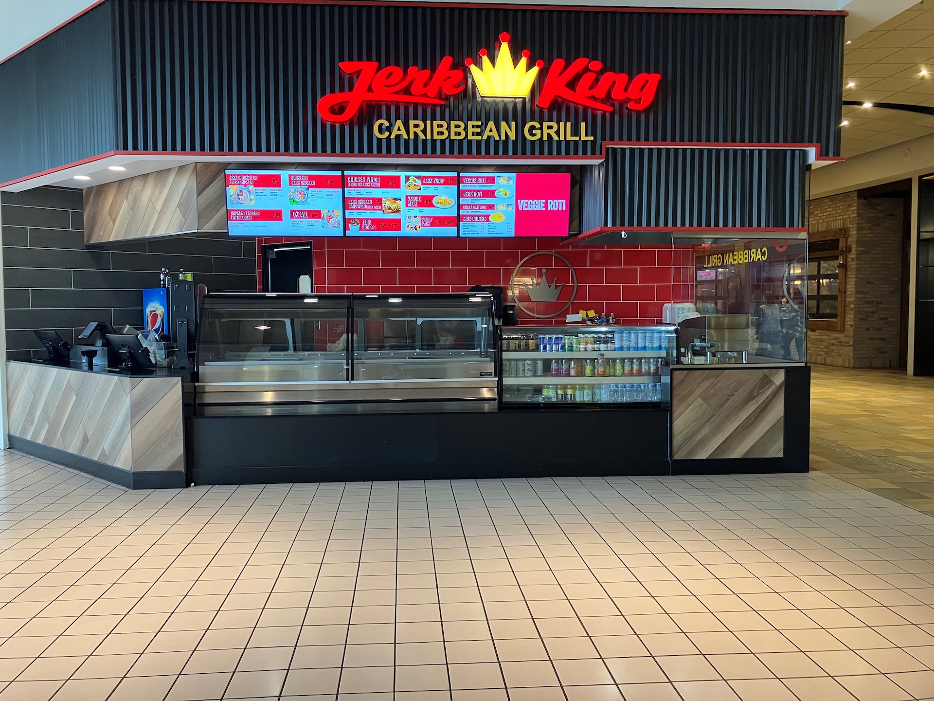 A restaurant in a food court with custom-made millwork and a well-lit food display case.