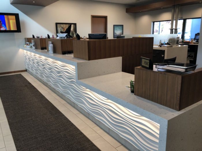 A modern bank teller counter area with custom millwork.